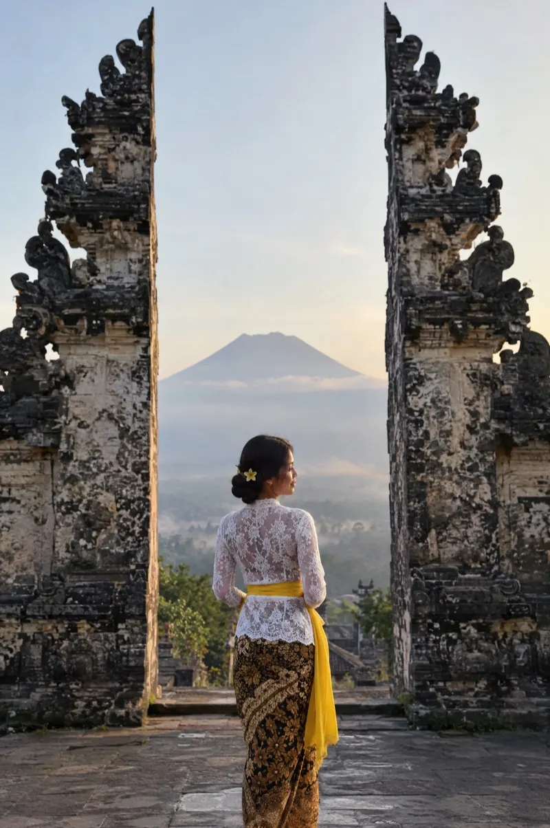 Woman in a kebaya at the Lempuyang temple gate with Mount Agung