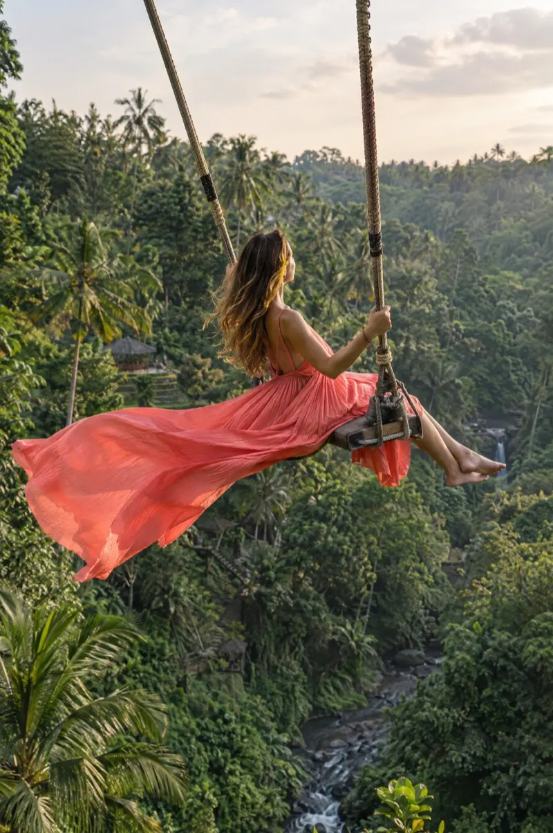 Woman in a flowing dress on the jungle swing above the Ubud valley