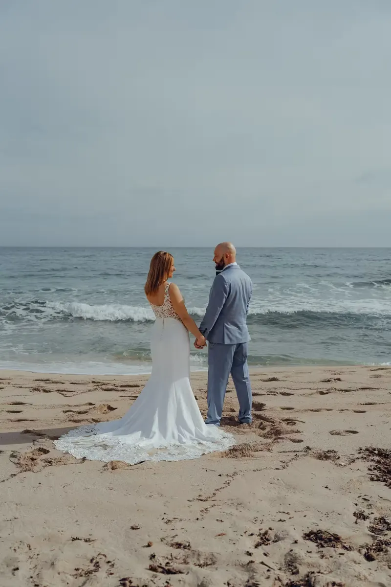 Bride and groom celebrating with a champagne toast on the beach