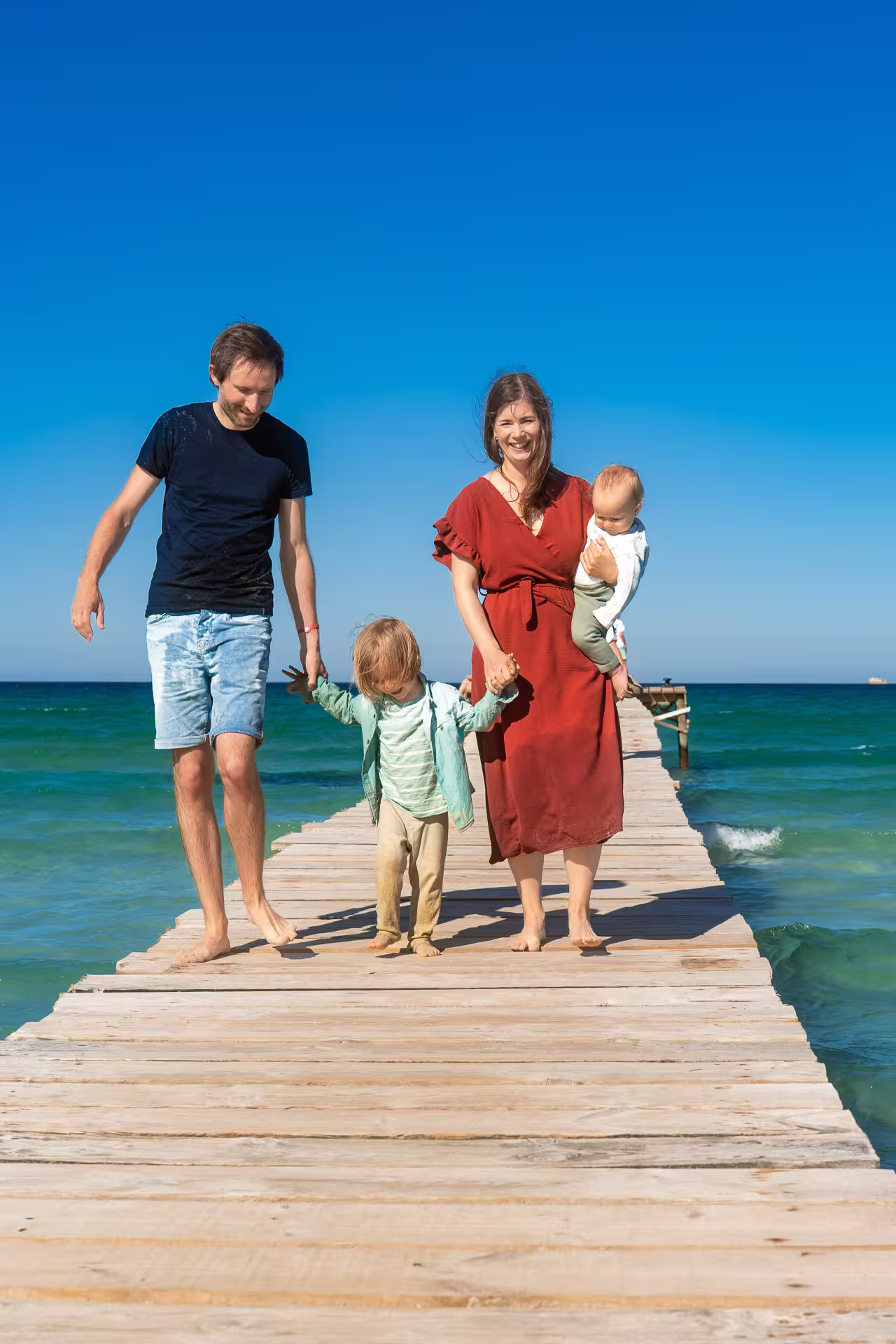 Young family walking on the pier in Alcudia