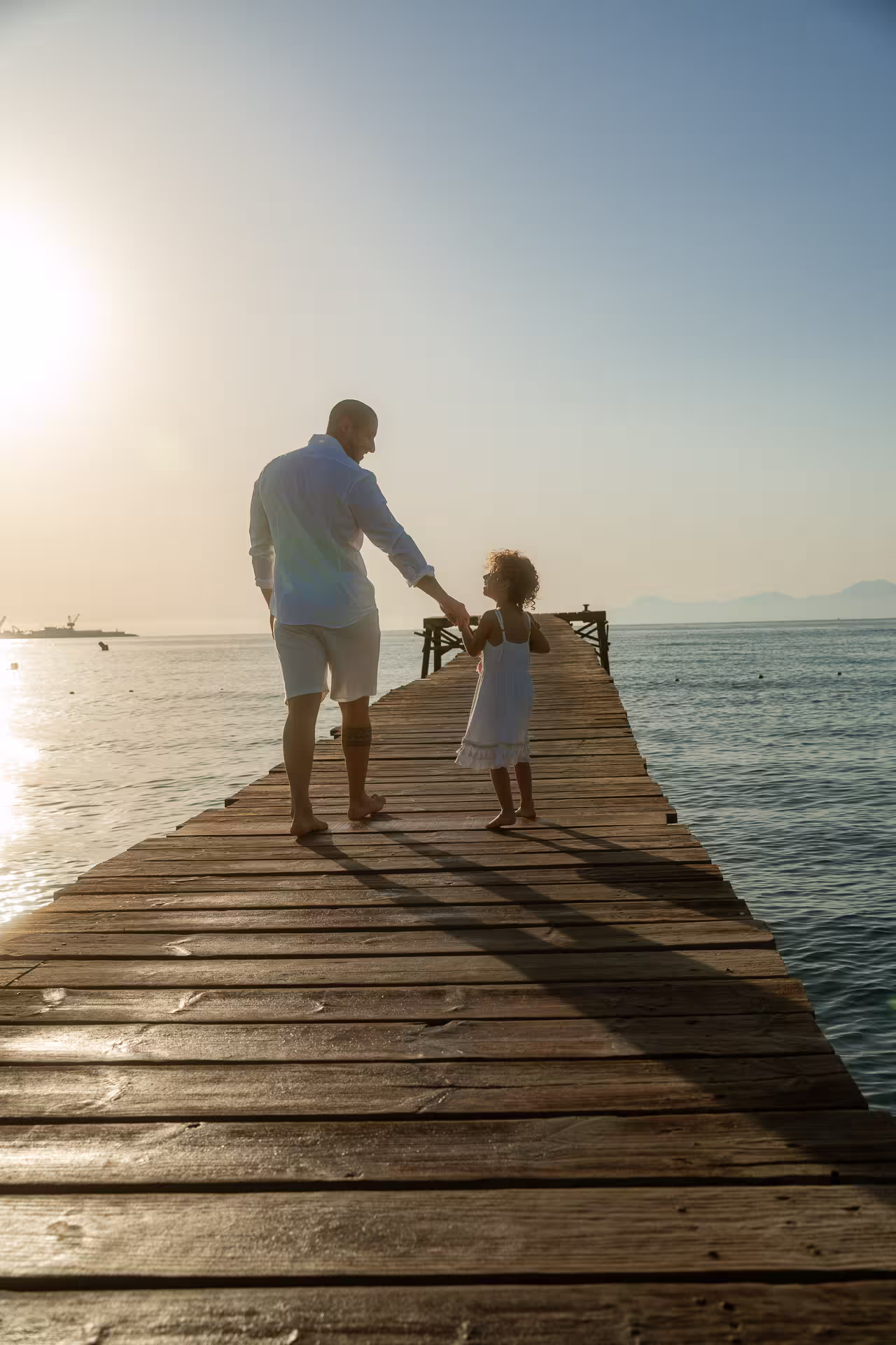 Father and little daughter walking on the pier in Alcudia