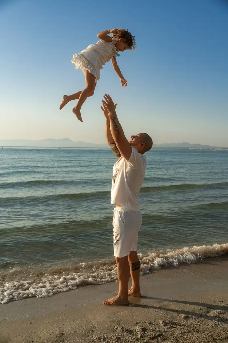 Vater wirft seine Tochter hoch in die Luft beim Fotoshooting Alcudia