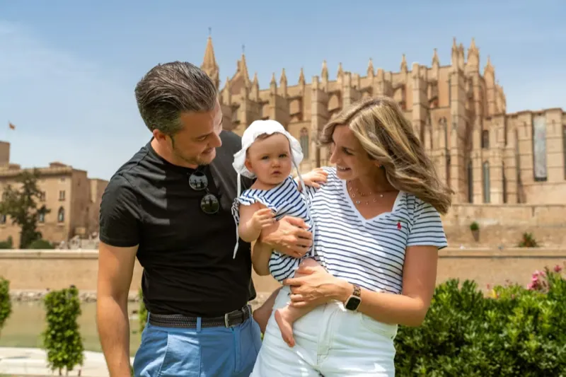 Junge Familie mit Baby vor der Kathedrale von Palma