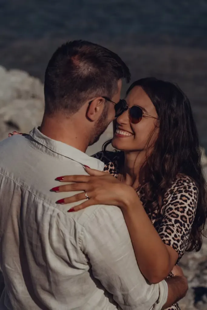 Close-up of a newly engaged couple looking at each other happily on the beach