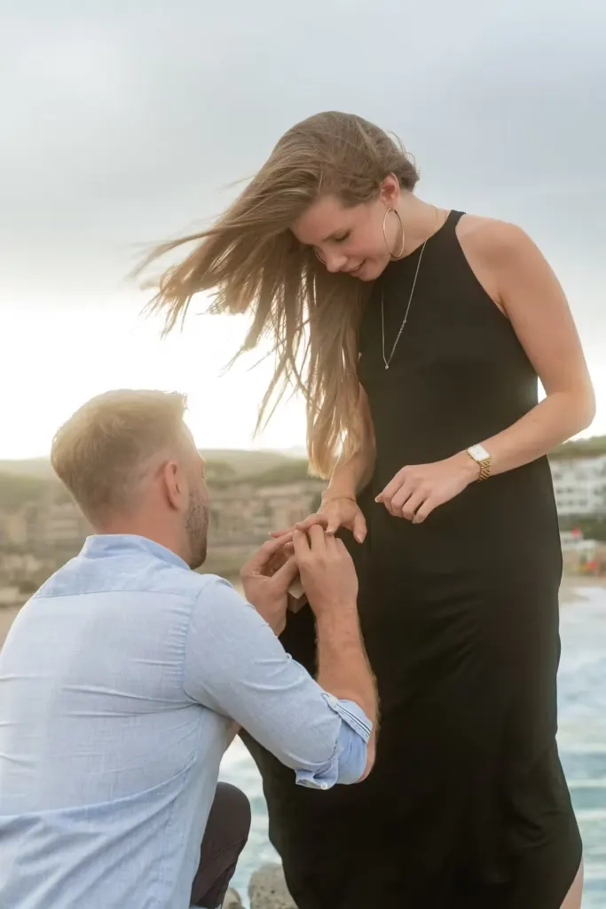 Close-up of a man placing an engagement ring on his partner's finger