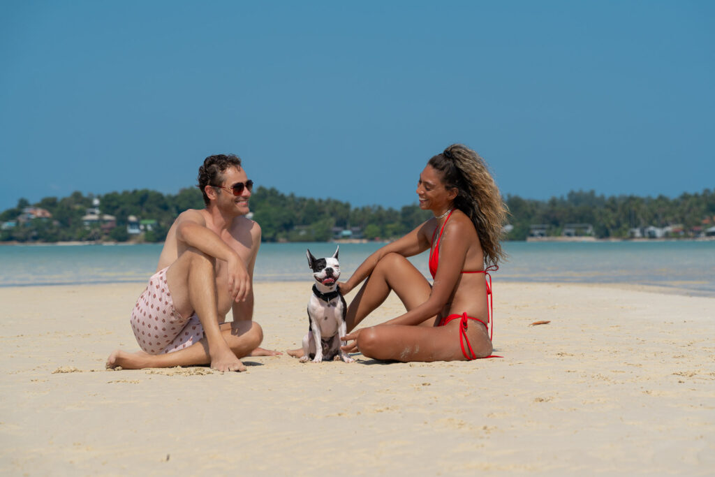 Couple photo shoot in Thailand – man and woman sitting relaxed in the sand