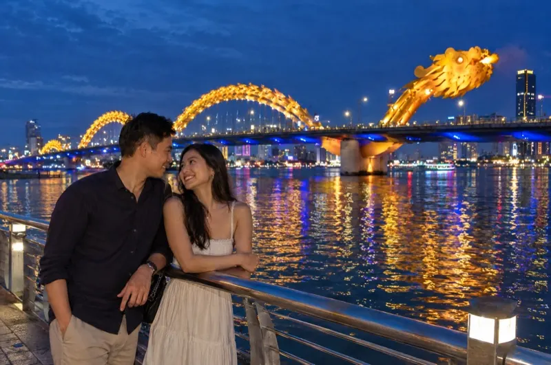 Couple photoshoot in Da Nang – couple on the Han River in front of the illuminated Dragon Bridge