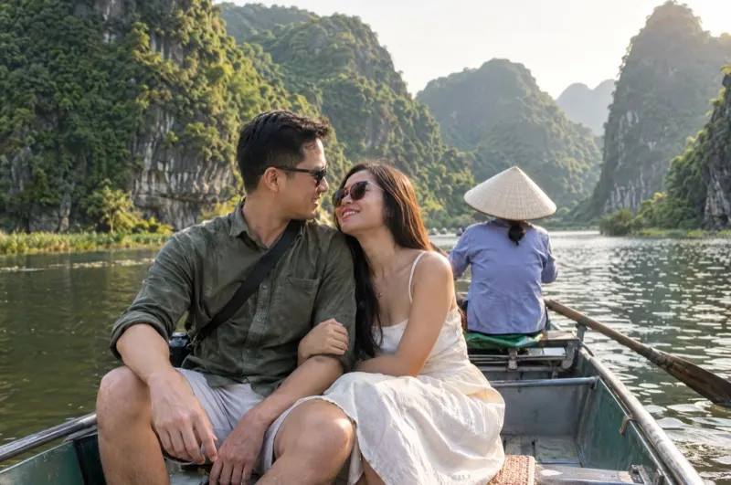 Couple photoshoot in Vietnam – couple in a rowing boat between the karst mountains of Trang An, Ninh Binh
