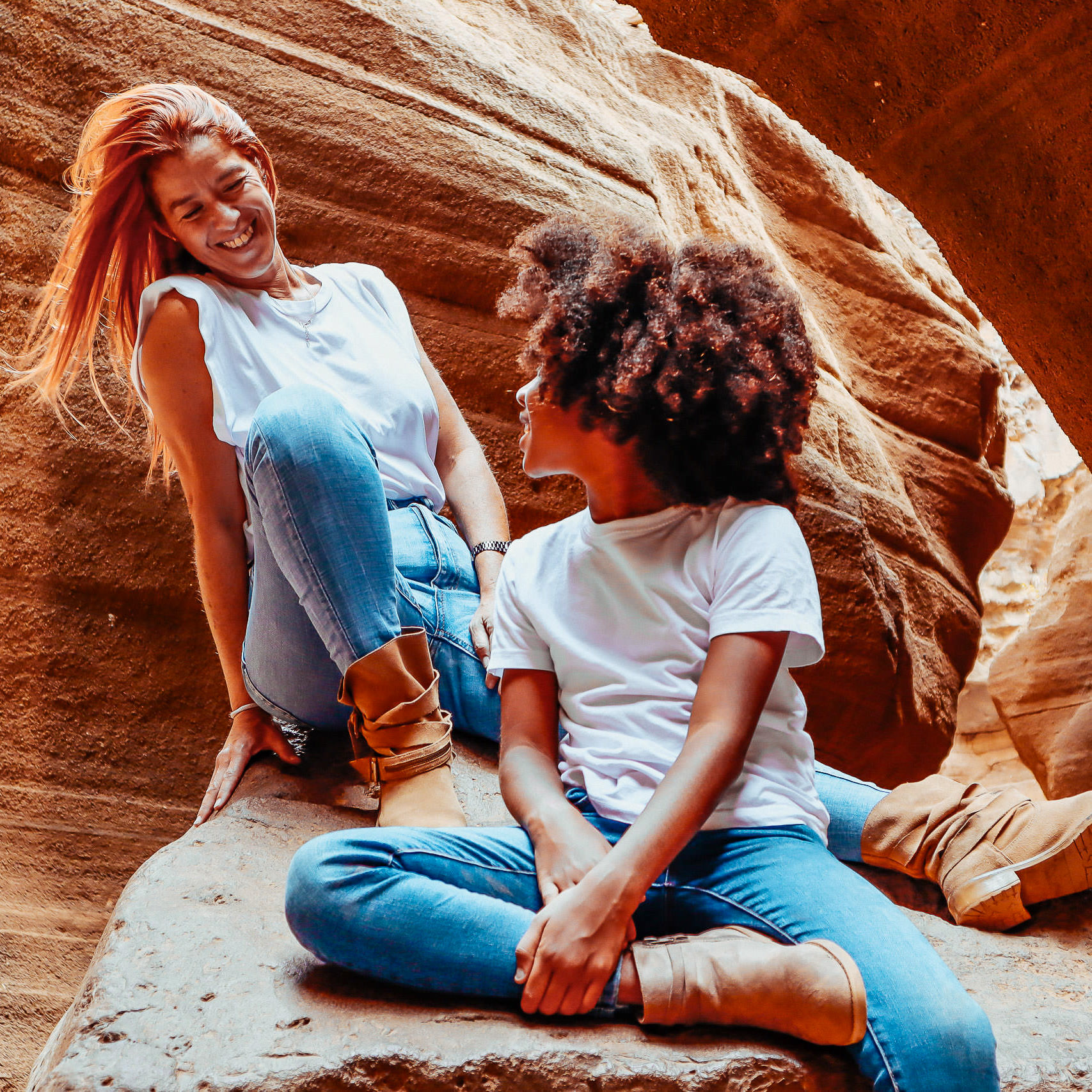 Urlaubs Fotoshooting Mutter sitzt mit ihrem Kind auf einem Stein
