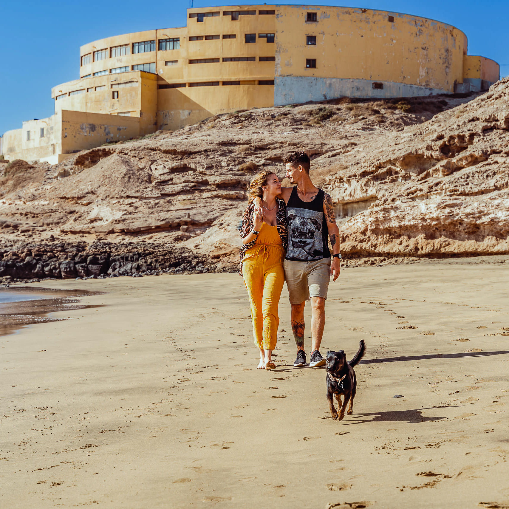 Urlaubs Fotoshooting Junges Paar läuft am Meer mit ihrem Hund