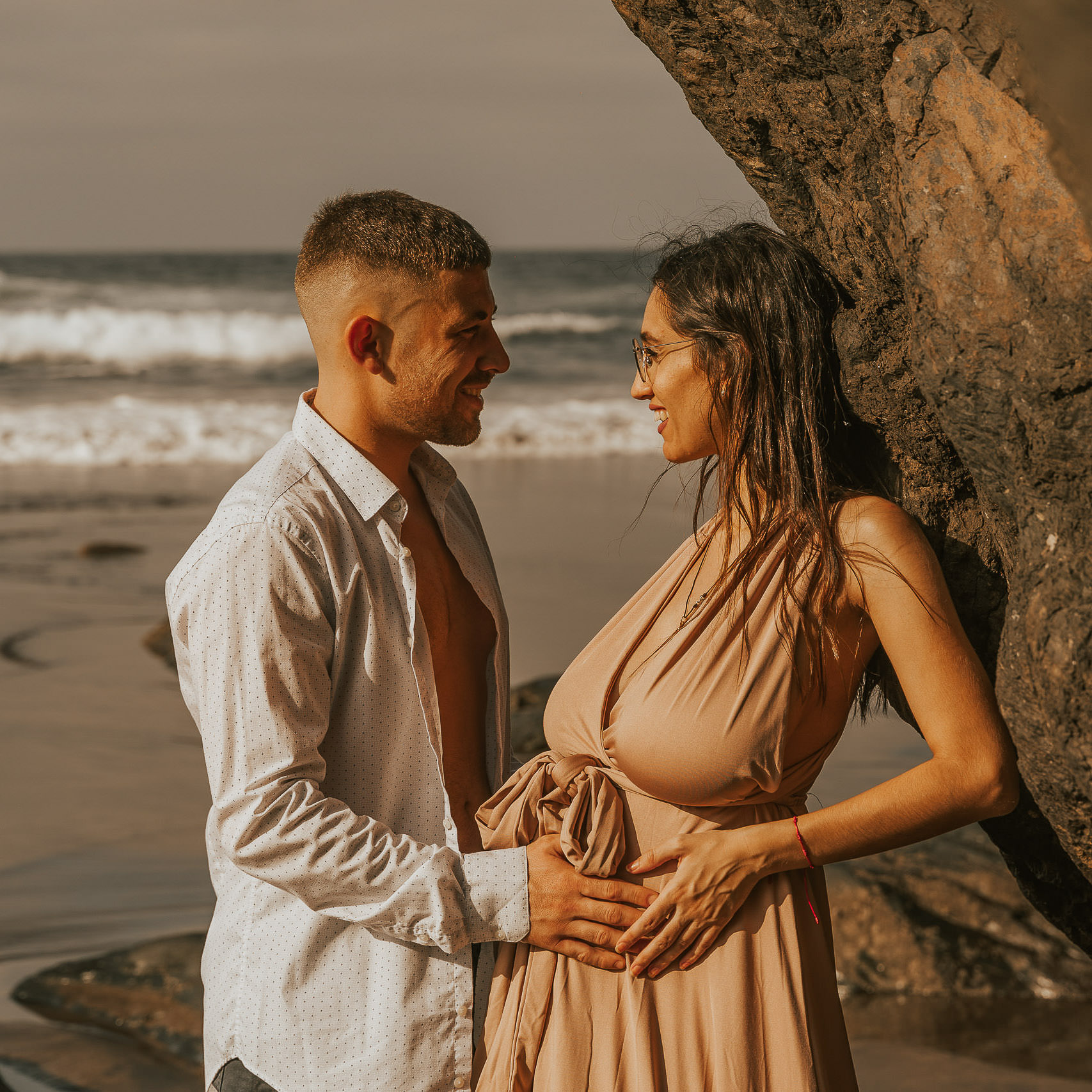 Urlaubs Fotoshooting Junges Paar hält glücklich den Babybauch