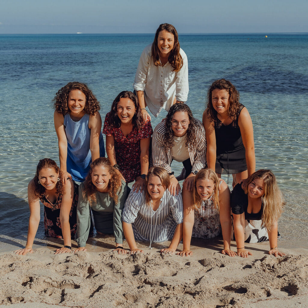 10 Freundinnen machen eine Pyramide am Meer