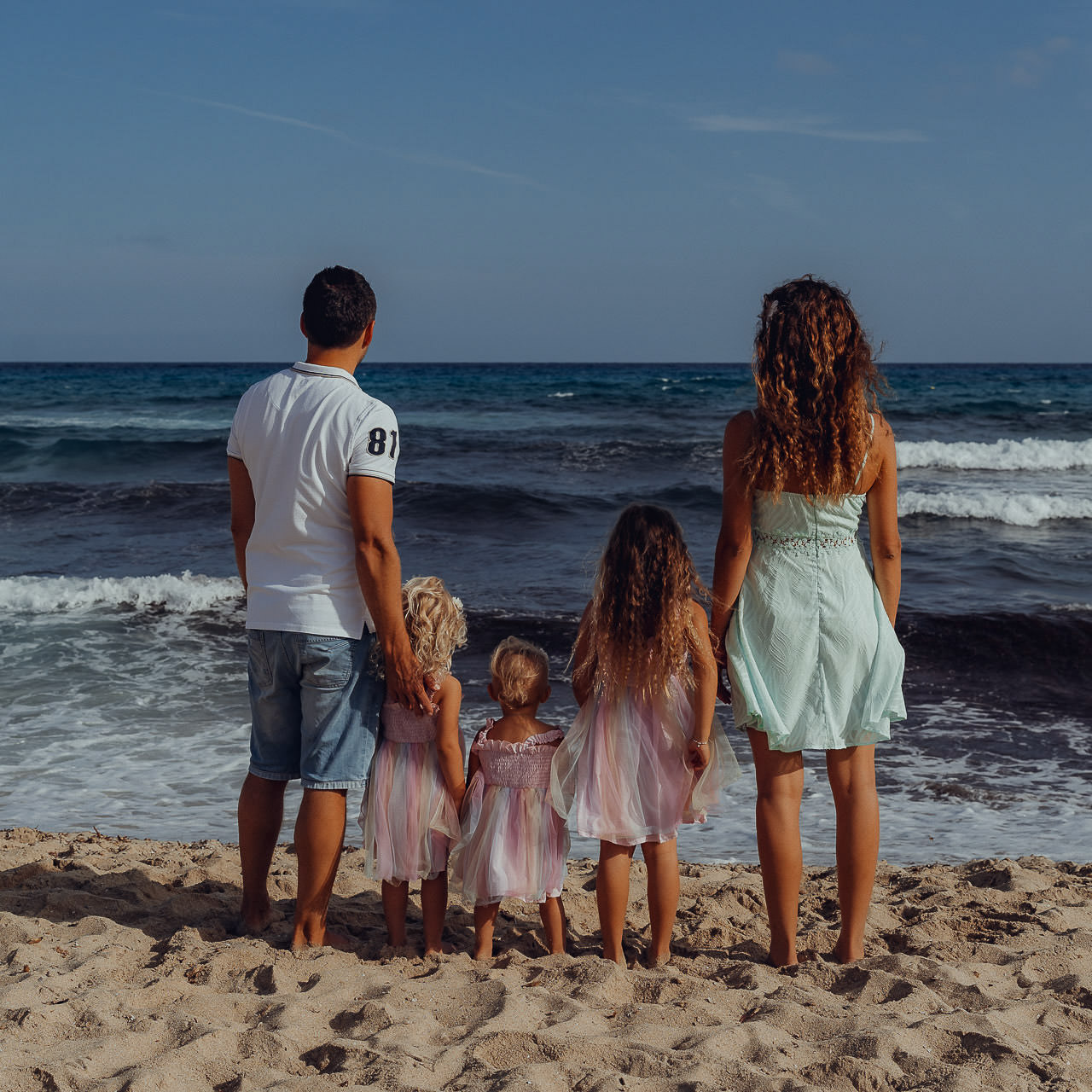 Urlaubs Fotoshooting Familie mit 2 Kindern blickt auf Meer