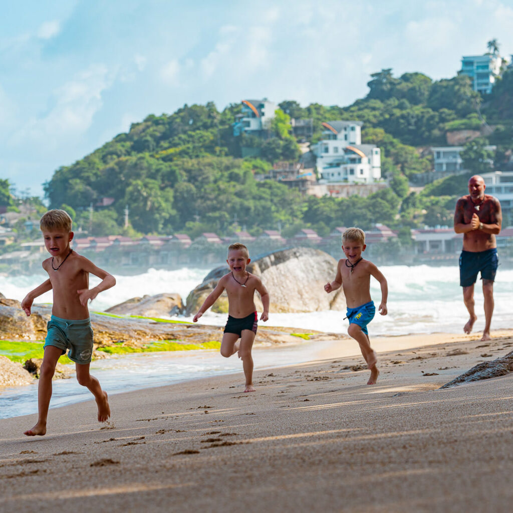 3 Jungs machen wettlaufen am Strand und Papa kommt nicht hinterher
