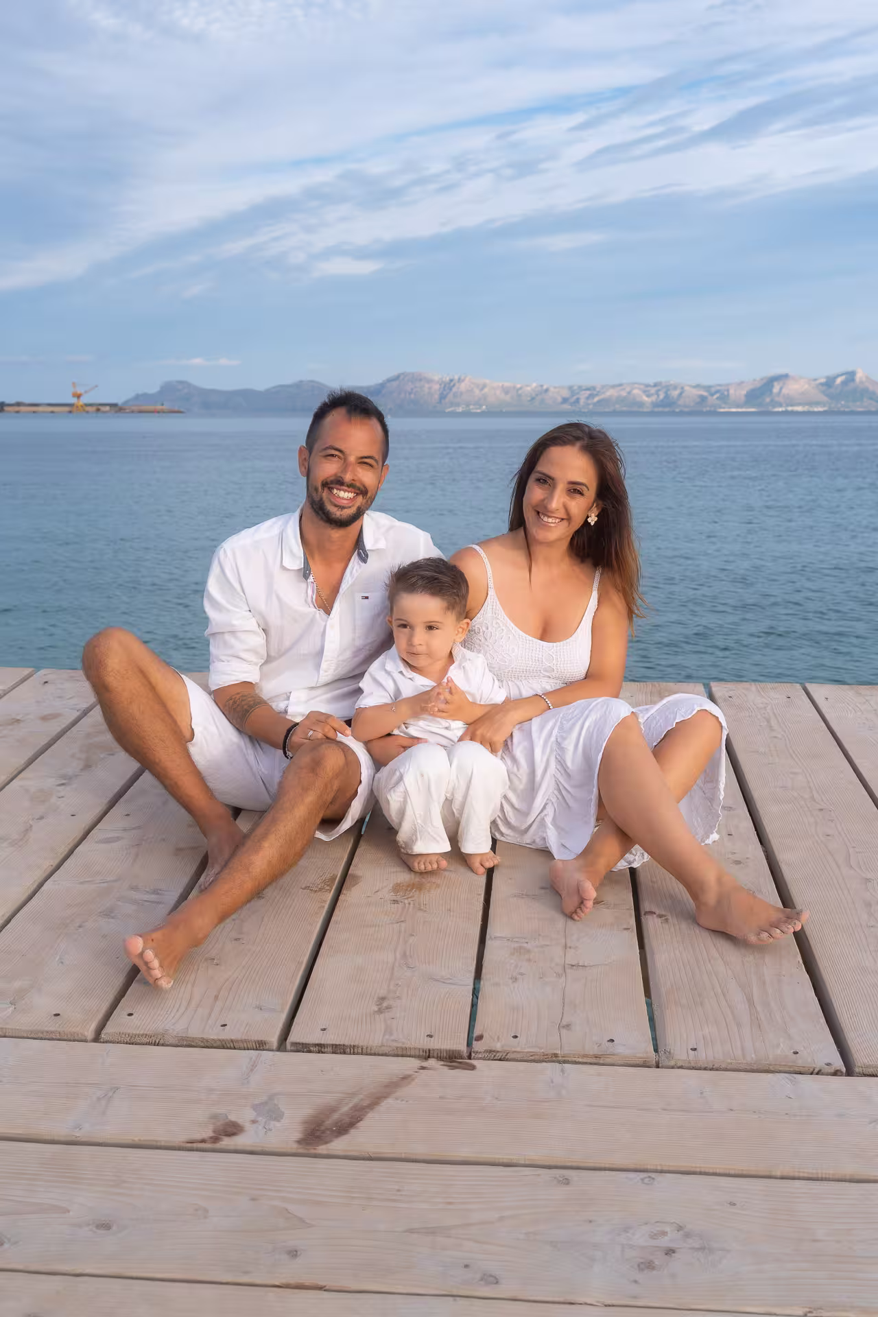 Familie ist fröhlich auf dem Holzsteg in Alcudia