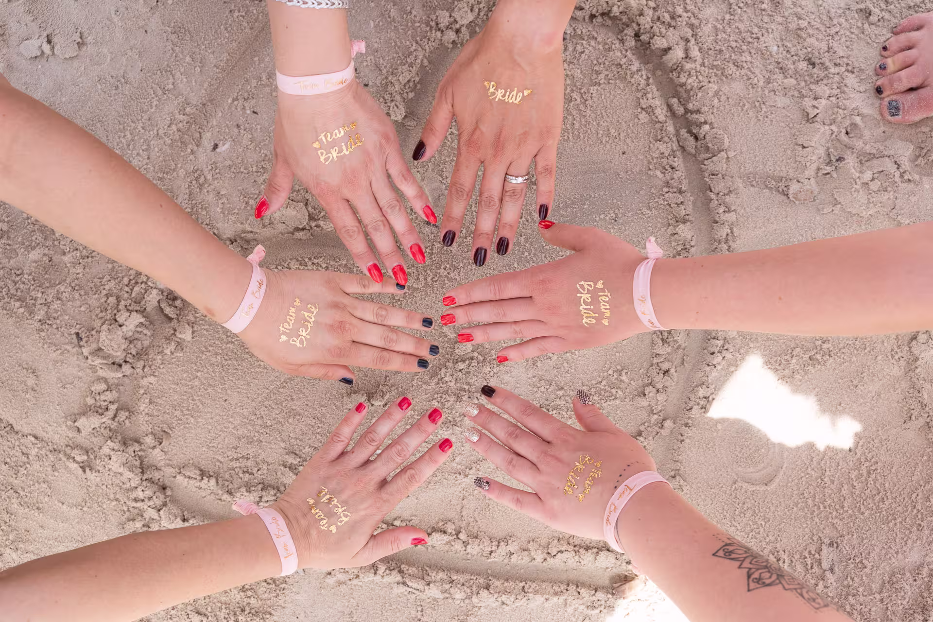 Fotoshooting JGA Mallorca: Detailaufnahme von Händen der JGA-Gruppe, die mit goldenen 
