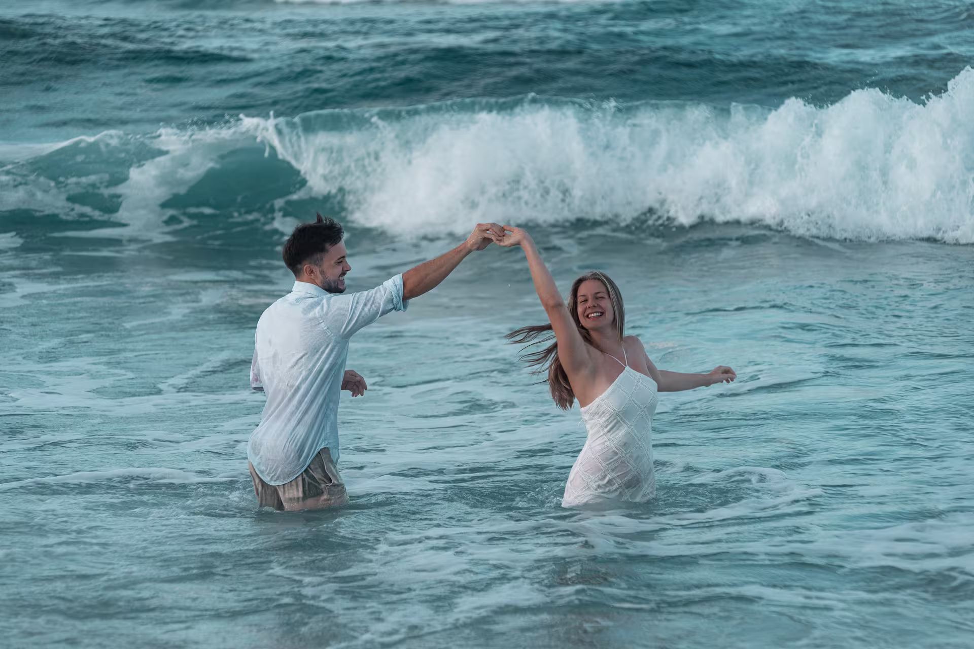 Ibiza-014-www.urlaubsfotoshooting.com Paar Fotoshooting auf Ibiza im Meer – romantische Szene beim Tanzen in den Wellen, aufgenommen vom Ibiza Fotograf.