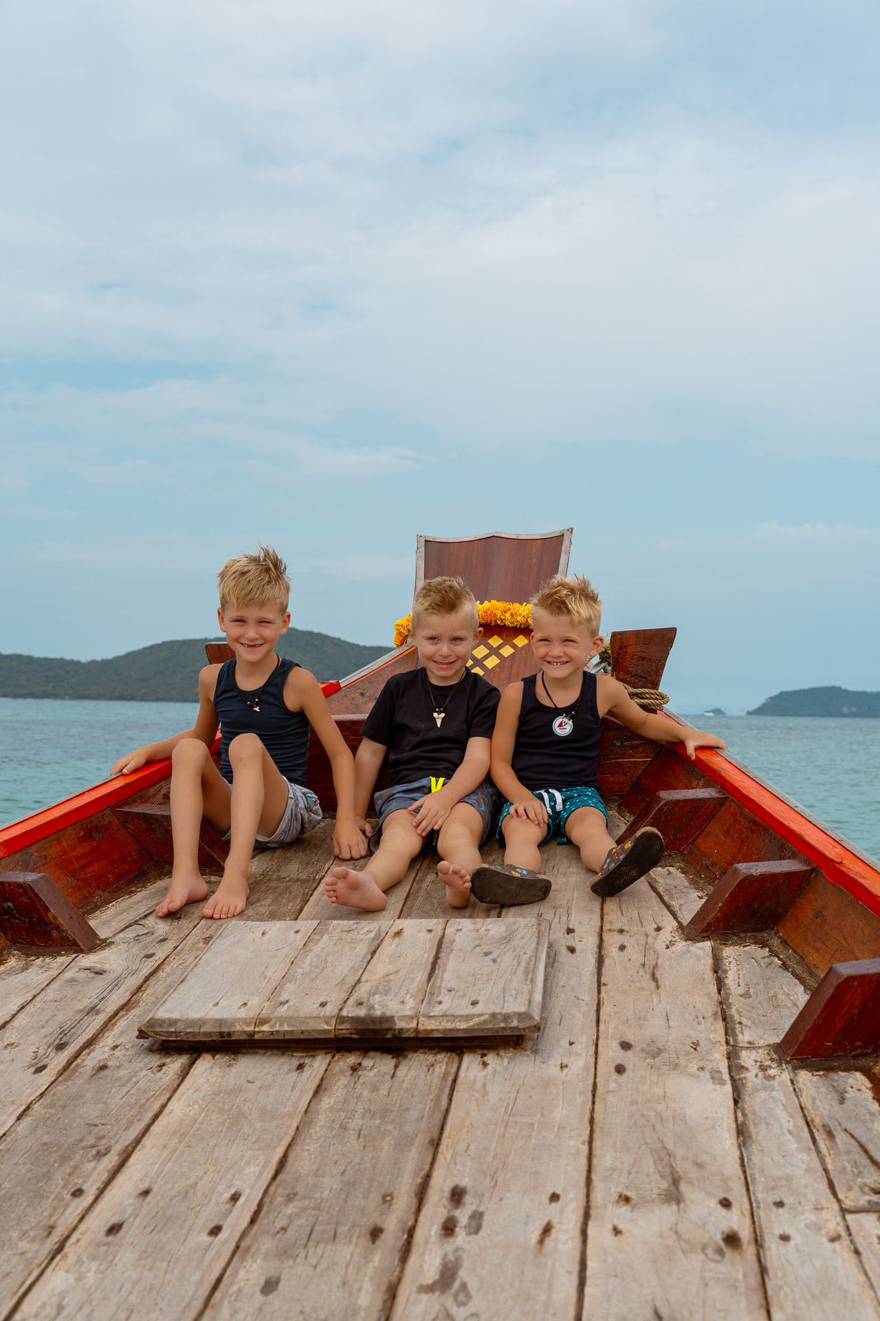 Thailand Urlaubs Fotoshooting auf dem Longtail-Boot – drei Kinder genießen das Abenteuer auf dem Meer, fotografiert von Thailand Fotograf.